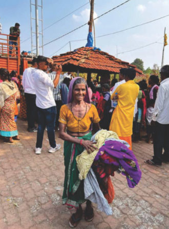 A woman carrying donated clothes in a tribal village