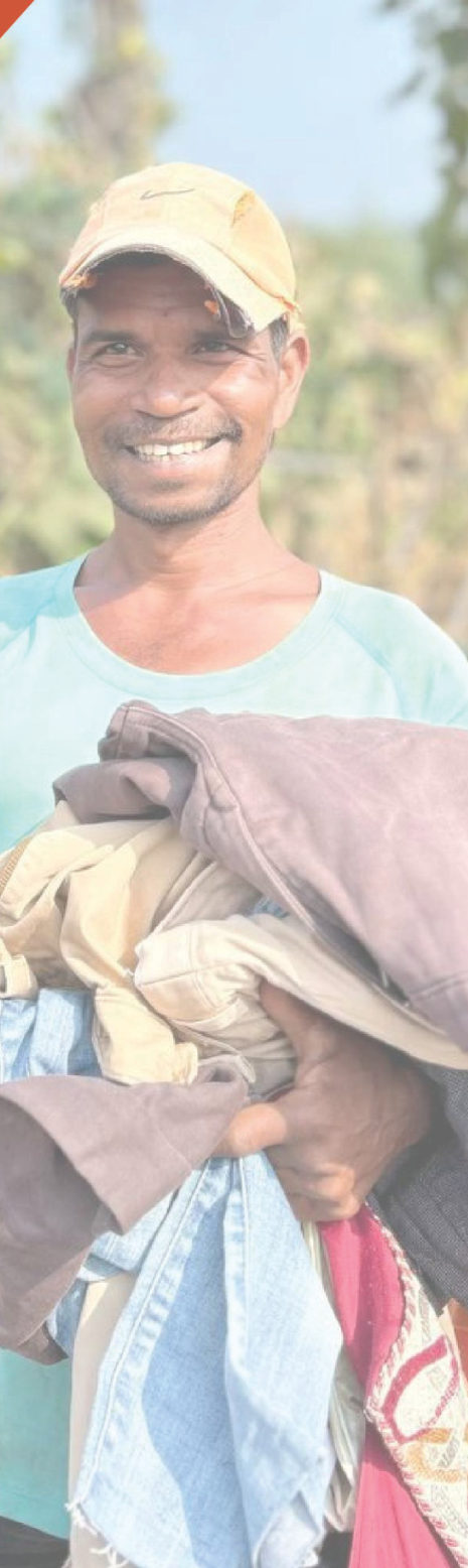 A smiling man holding donated clothes