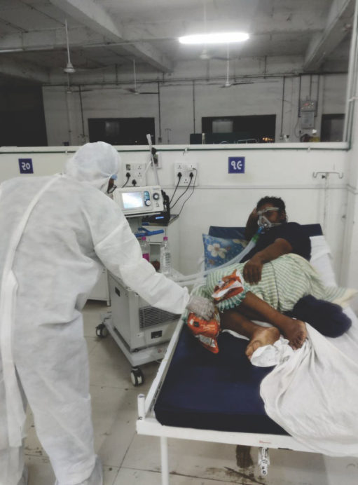 Volunteer in PPE caring for a patient